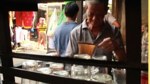 A Chinese street vendor making coffee with a cloth filter.
