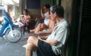 Chinese men relaxing in front of their houses.